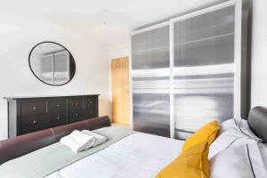 een slaapkamer met een groot bed en een spiegel bij Spacious 2 Bedroom Apartment In Central Near tube in Londen