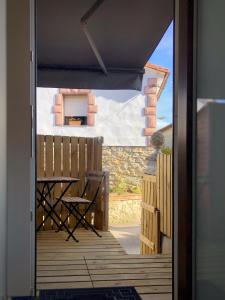 una puerta abierta a un patio con mesa y sillas en Apartamento con terraza, en San Vicente de la Barquera