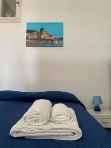 1 dormitorio con 1 cama con toallas en Marger Apartments, en Santa Maria di Castellabate