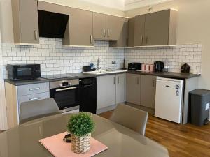 a kitchen with a table and chairs in a room at Cozy Victorian Gem • Near Hospitals & Attractions in Sheffield