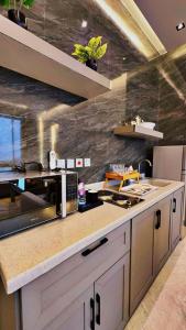 a kitchen with a counter top with a microwave at شاليهات اطلالات Abha Sky المميزه in Abha