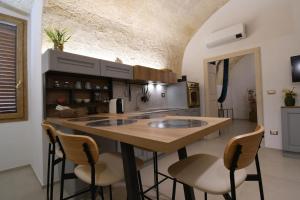 a kitchen with a large wooden island with bar stools at LA FINESTRA SUL PONTE in Gravina in Puglia