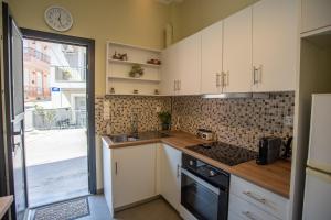 a kitchen with white cabinets and a sink and a stove at Two Bedroom Apartment, Mytilene Lesvos in Mytilini
