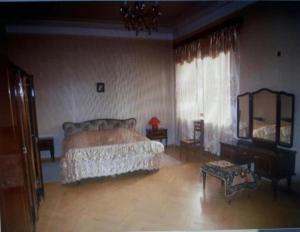 1 dormitorio con cama, mesa y espejo en Guli, en Gori