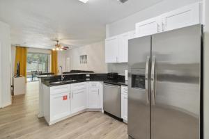 een keuken met witte kasten en een roestvrijstalen koelkast bij Bella Point View in Davenport