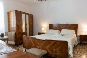 - une chambre avec un grand lit et une tête de lit en bois dans l'établissement Camera tra le Cinque Terre, Camogli e Portofino. Vista valle e scorcio mare all'orizzonte, à Castiglione Chiavarese