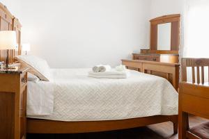 una camera con letto bianco, cassettiera e specchio di Camera tra le Cinque Terre, Camogli e Portofino. Vista valle e scorcio mare all'orizzonte a Castiglione Chiavarese