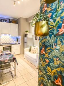 a living room with a kitchen and a pot with a plant at A casa di Gin Milano in Milan