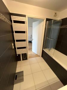 baño con ducha a ras de suelo y espejo en Appartement moderne et agréable, idéalement placé pour JO 2024, en Puteaux