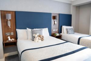 twee bedden in een hotelkamer met teddyberen erop bij The Western Hotel in Galway