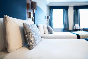 um quarto de hotel com duas camas e um sofá em The Western Hotel em Galway