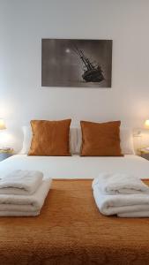 sypialnia z łóżkiem z białą pościelą i brązowymi poduszkami w obiekcie Sherryflat Torneria- Parking w mieście Jerez de la Frontera
