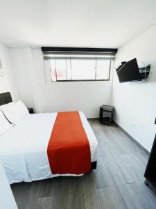 a bedroom with a bed and a window in it at Hotel Portal de los Andes in Bogotá