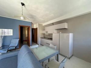 a living room with a couch and a table and a refrigerator at Casa Mare Atene in Follonica