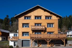 ein großes Holzgebäude mit Balkon in der Unterkunft la grande cabane du Blanc Ruxel in Xonrupt-Longemer