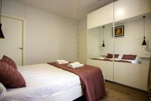 1 dormitorio con 2 camas y espejo en RentalSevilla en Triana, en Sevilla