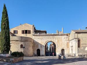 un edificio antiguo con un arco en un patio en Cairoli Lifestyle, en Fano