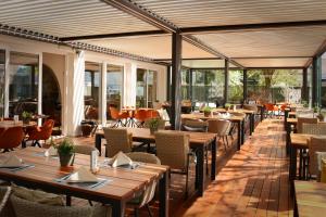 a restaurant with wooden tables and chairs and windows at Parkhotel Langenthal in Langenthal