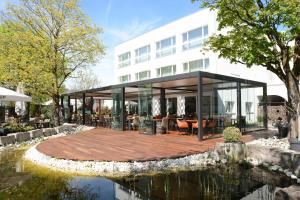 een weergave van een gebouw met een terras en een vijver bij Parkhotel Langenthal in Langenthal