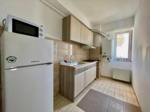 a kitchen with a white refrigerator and a sink at Summerland Apartmants mamaia nord in Mamaia