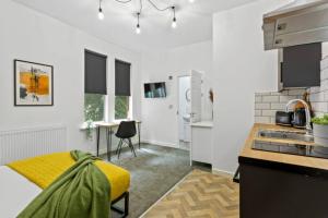 a kitchen with white walls and a yellow couch in a room at Nottingham Group Stay - 8 x Studio Apartments, sleeps 16, Free Parking in Nottingham