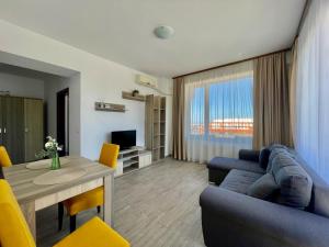 a living room with a blue couch and a table at Summerland Apartmants mamaia nord in Mamaia