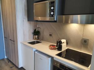 a kitchen with a sink and a microwave at Luxury Menlyn Maine Apartment in Pretoria