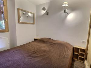 ein Schlafzimmer mit einem Bett und zwei Lampen an der Wand in der Unterkunft Appartement Méribel, 2 pièces, 6 personnes - FR-1-182-102 in Méribel