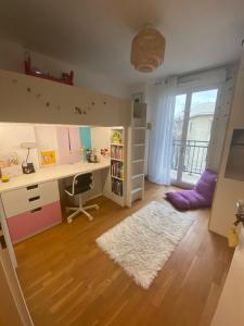ein Kinderzimmer mit einem Schreibtisch und einem Bücherregal in der Unterkunft Chaleureux et lumineux appartement in Puteaux