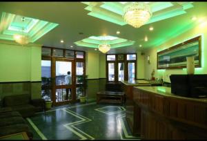 eine Bar in einem Restaurant mit grünen Wänden und Kronleuchtern in der Unterkunft Hotel Abhinandan Mussoorie Near Mall Road - Parking Facilities & Prime Location - Best Hotel in Mussoorie in Masuri