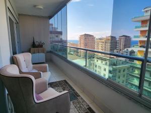a balcony with two chairs and a view of a city at Cozy Sea view next to the beach, in the mid of the market, Saturday bazar, restaurants & bars etc, Alanya Mahmutlar! in Alanya