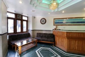 uma sala de estar com um sofá e um piano em Hotel Abhinandan Mussoorie Near Mall Road - Parking Facilities & Prime Location - Best Hotel in Mussoorie em Mussoorie
