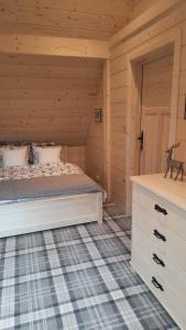 a bedroom with a bed in a log cabin at Góralska Chata przy Dolinie Chochołowskiej in Witów
