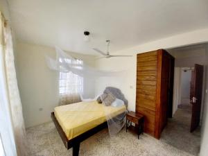 Dado's Place في كاليبيشي: غرفة نوم بسرير وخزانة ونافذة