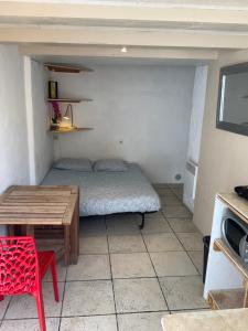 Cette petite chambre comprend un lit et une table. dans l'établissement Plus belle la vie ici, à Marseille