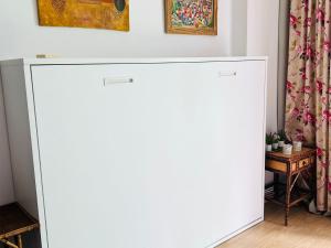 a large white cabinet in a room with a table at Espectacular apartamento con piscina y garaje in Madrid