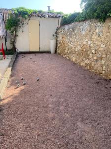 um quintal com pedras no chão ao lado de uma parede em Plus belle la vie ici em Marselha