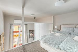 een witte slaapkamer met een bed en een raam bij Elizabeth Boulevard Unity in Boedapest