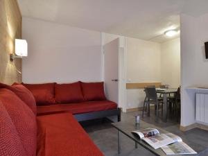 een woonkamer met een rode bank en een tafel bij Appartement Plagne Bellecôte, 2 pièces, 5 personnes - FR-1-181-2014 in La Plagne Tarentaise