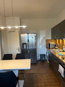 a kitchen with a stainless steel refrigerator and a table at Duc Anh Ferienwohnung in Emden