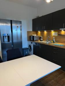 a kitchen with a white table and a refrigerator at Duc Anh Ferienwohnung in Emden