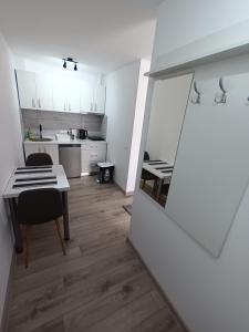 eine kleine weiße Küche mit einem Tisch und einem Esszimmer in der Unterkunft Old Town Studio 2 apartment nr 2 in Baia Mare