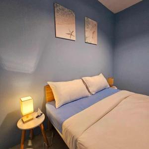 House of sea Jomtien beach في جومتين بيتش: غرفة نوم بسرير وطاولة مع مصباح