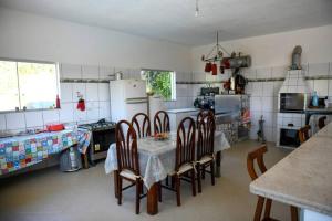 a kitchen with a table and chairs in it at Sítio agradável com piscina em Condomínio fechado in Brumadinho