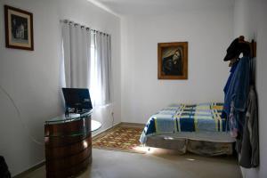a bedroom with a bed and a desk and a window at Sítio agradável com piscina em Condomínio fechado in Brumadinho