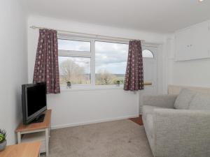uma sala de estar com um sofá e uma janela em 27 Fernhill Heights em Bridport