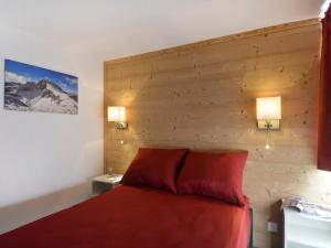 1 dormitorio con cama roja y pared de madera en Appartement Plagne Bellecôte, 5 pièces, 11 personnes - FR-1-181-2379, en La Plagne Tarentaise