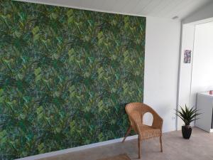 a chair in a room with a green wall at Grand studio centre ville Bretignolles in Bretignolles-sur-Mer