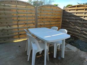 a blue table and chairs in front of a fence at Grand studio centre ville Bretignolles in Bretignolles-sur-Mer