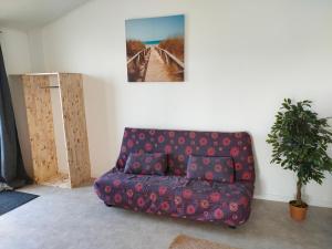 a couch in a living room with a picture on the wall at Grand studio centre ville Bretignolles in Brétignolles-sur-Mer